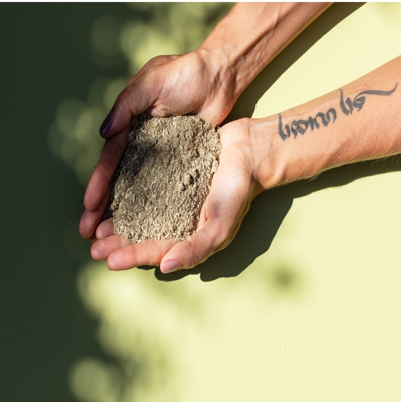 maos erva mate Mãos segurando erva-mate ao fundo de uma superfície verde claro.