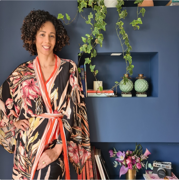 mulher sorrindo paleta cores mata atlantica Mulher, sorrindo e com a mão na cintura, em um ambiente com a paleta de cores da Mata Atlântica.