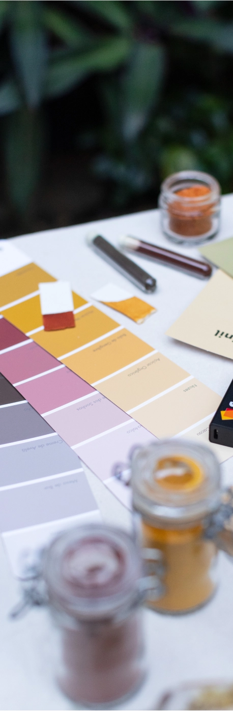 Paletas de cores e amostras de tintas sobre uma mesa.
