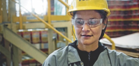 colaboradora epi fabrica suvinil Colaboradora com capacete e óculos de proteção (EPI) em uma fábrica da Suvinil.