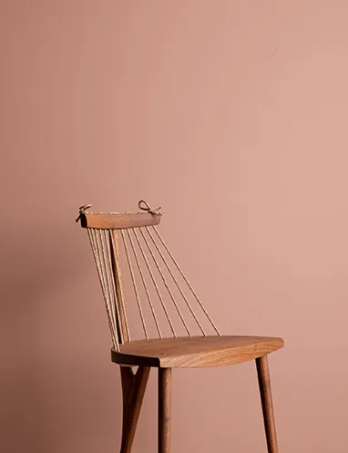 cor suvinil flor de anis Cadeira posicionada a frente de parede pintada com a cor Flor de Anis da Suvinil.